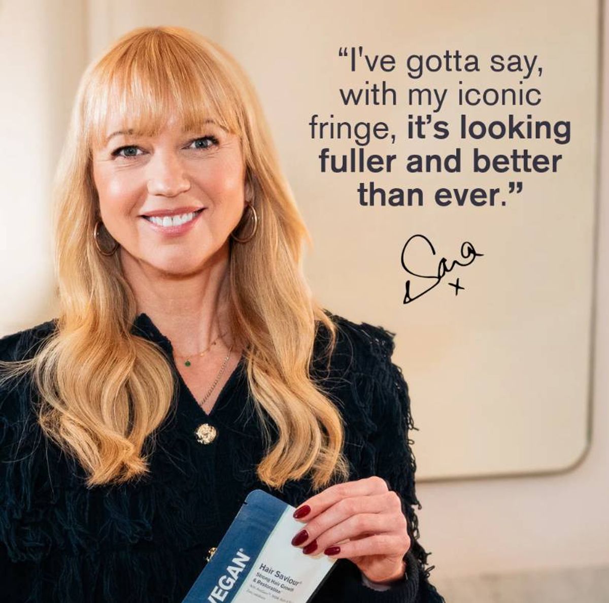 A smiling woman with long blonde hair, wearing a black top, stands in front of a wall with a quote attributed to her. The quote reads: "'You have to say, with my famous bracelet, it looks fuller and better than ever.'" The signature at the end of the quote is partially visible.