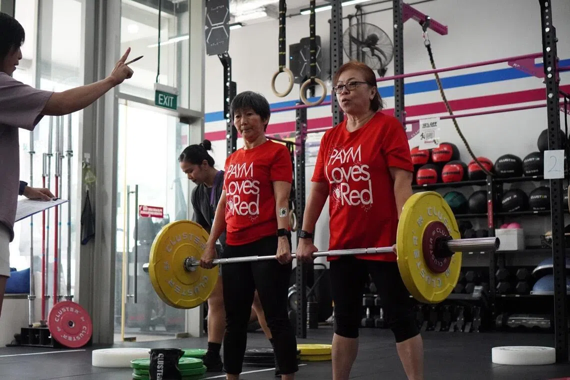 Ms Sharon Tan (left) and Ms Selina Chua do partner barbell deadlifts at Rx Performance in Outram.