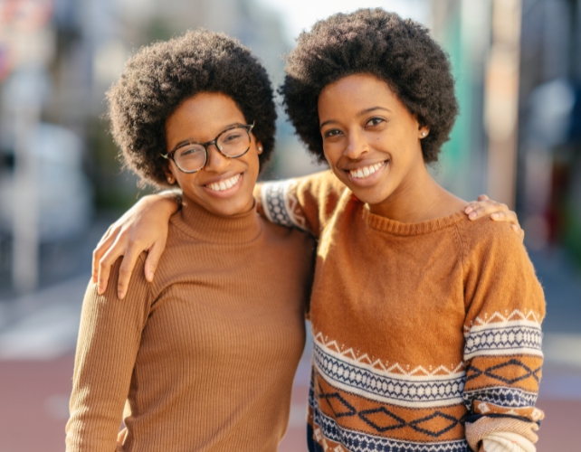 Two sisters smiling with arms around each other