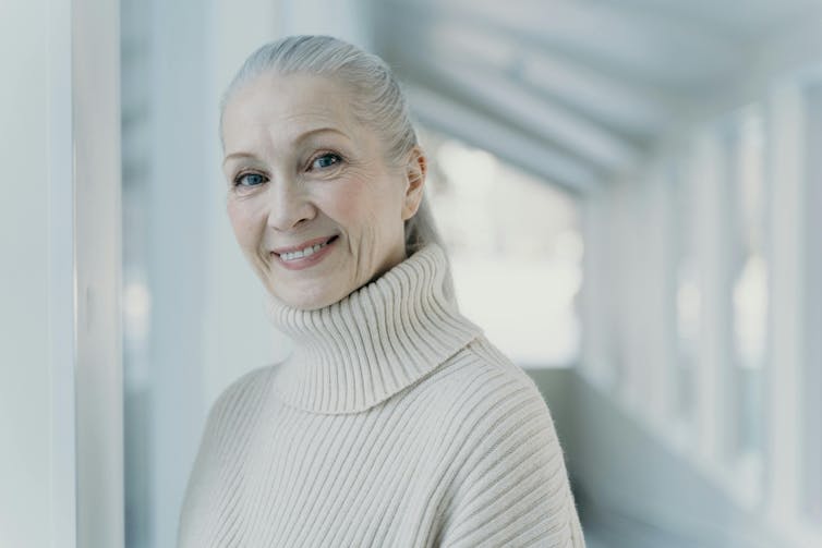 A woman with gray hair turned back with a smile