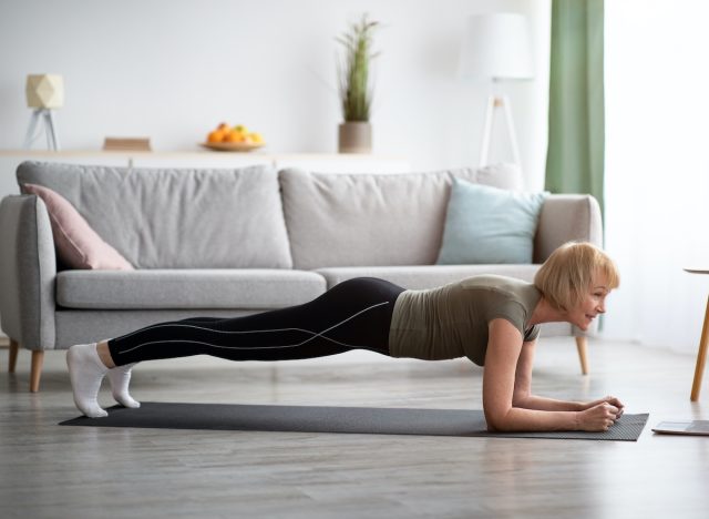 Woman practicing planks in living room