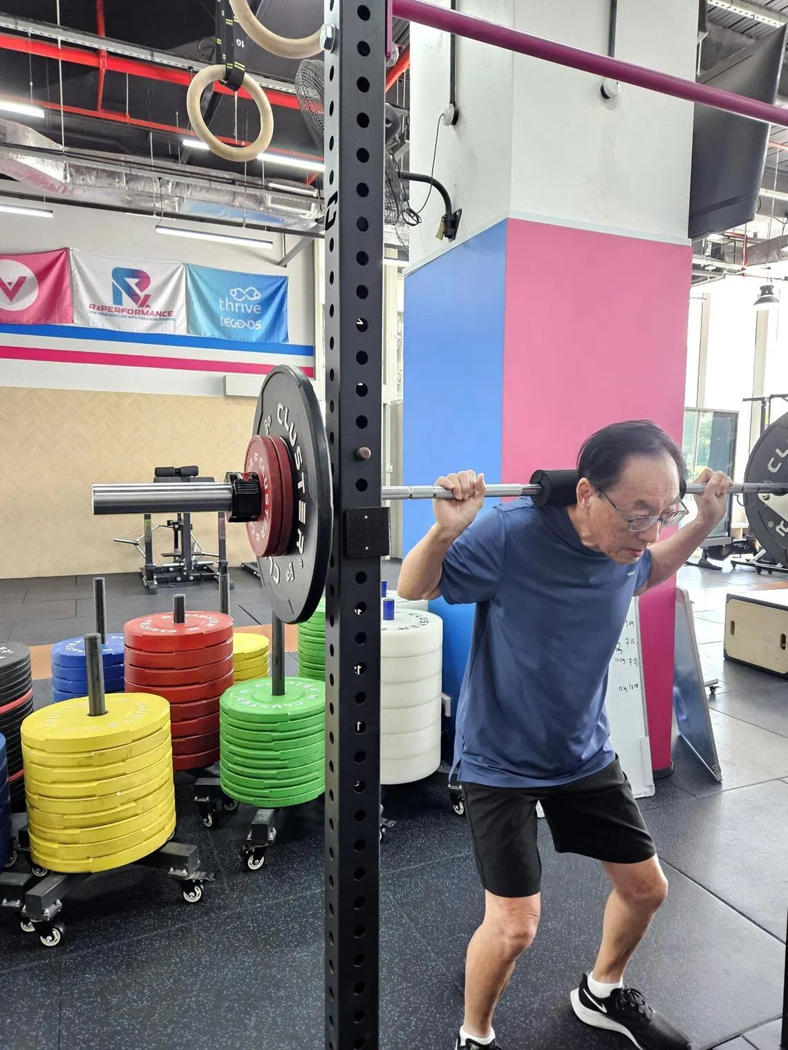 Mr Steven Tan, 74, squats back at Rx Performance in Outram.