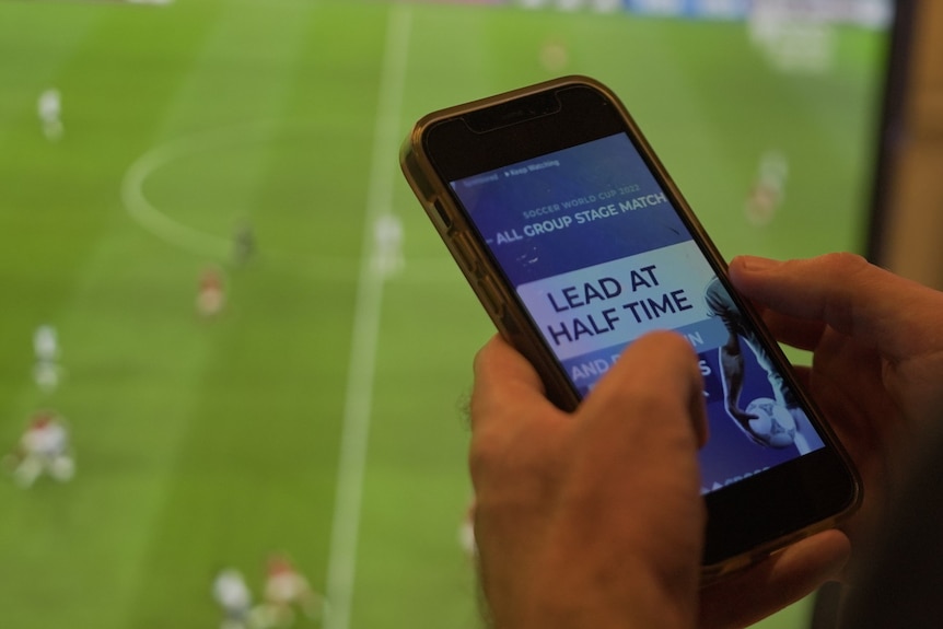 Mobile phone in hands showing gambling app.